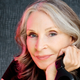 Star Trek: The Next Generation actor Gates McFadden holding a pair of headphones to promote her podcast.